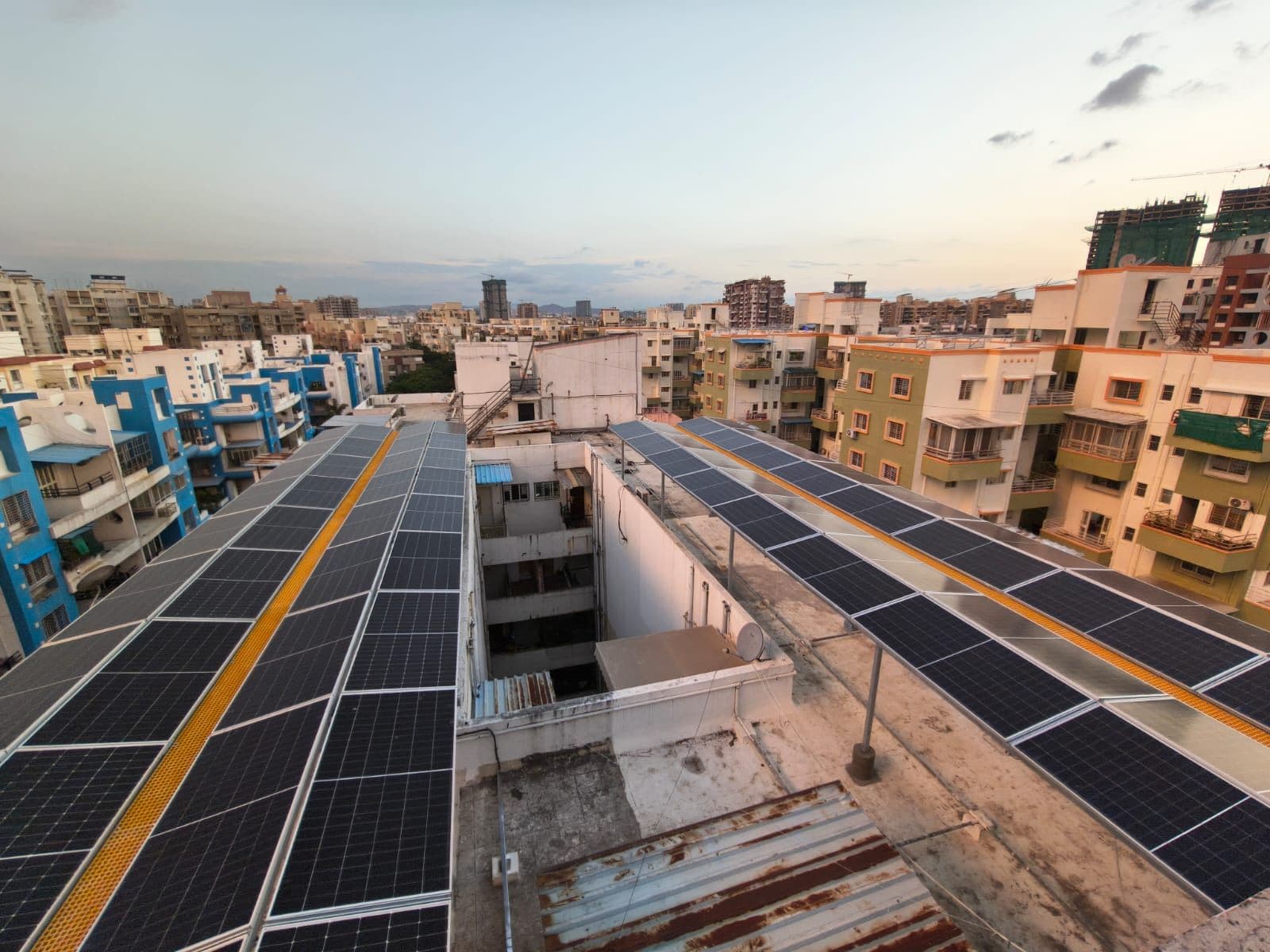 Walkway between rows of rooftop solar panels in golden evening light