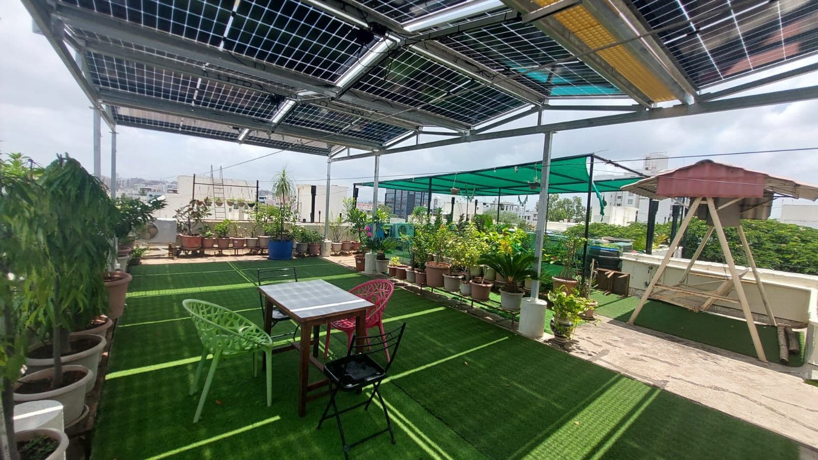 Shaded rooftop deck with seating underneath raised solar panels
